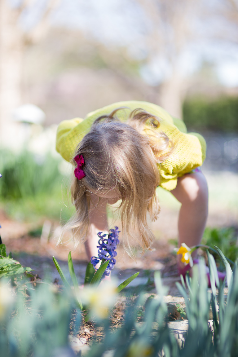 girl smelling flower at Botanica Wichita